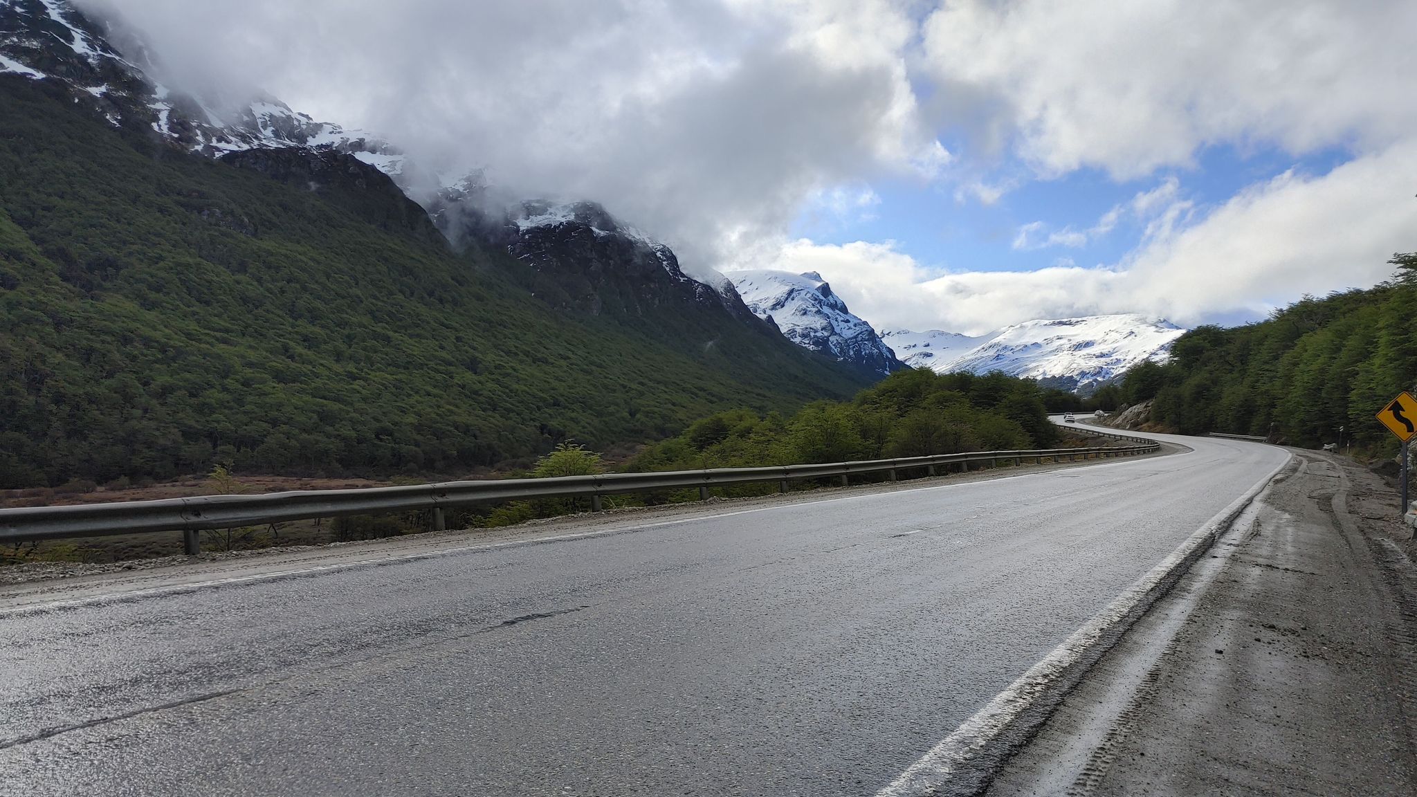 Scenic mountain road with snow-capped peaks representing the journey of digital nomads and travelers