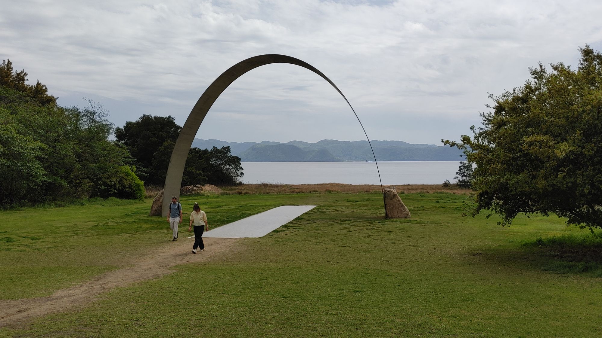 large metal arch with a couple walking away