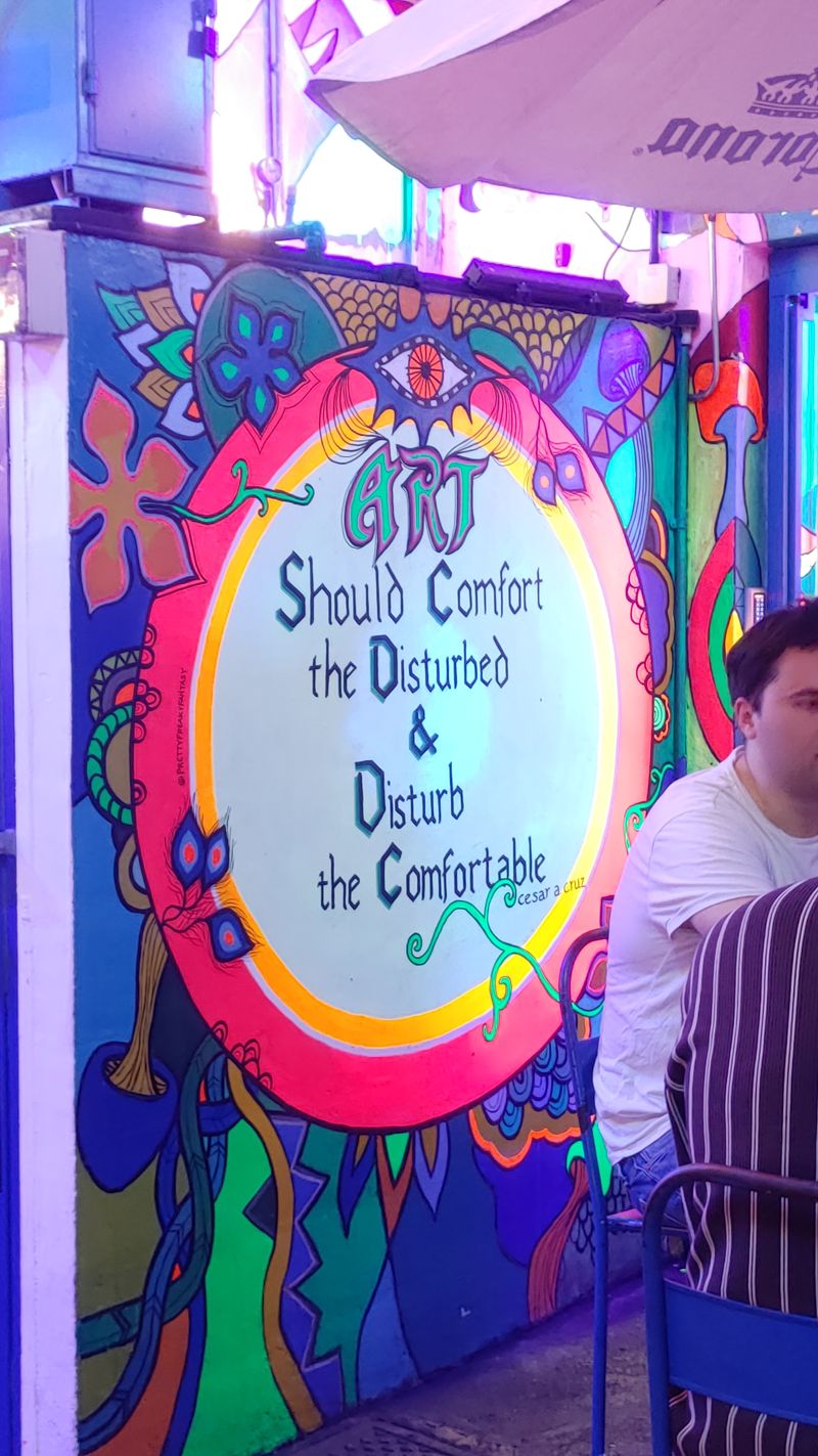 painted message on the side of the same building saying Art should comfort the disturbed and disturb the comfortable