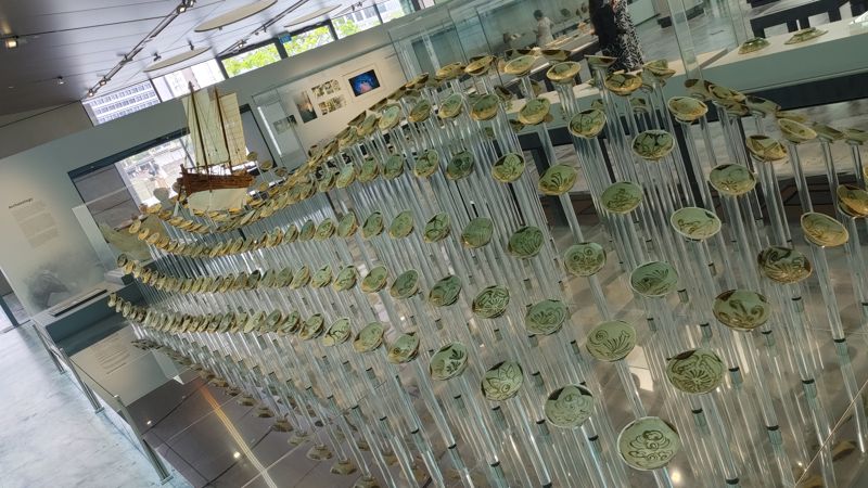 shipwrek pottery pieces with model ship arranged like ways in the ocean