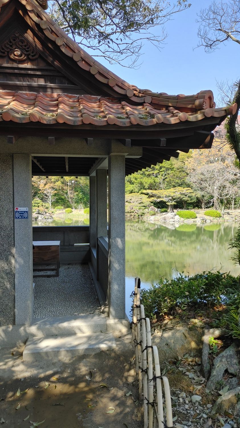 small stone Japanese hut overlooking a pond